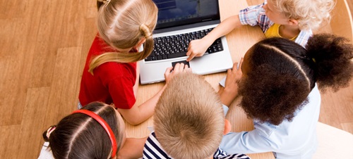 Elementary students work on a laptop in class.