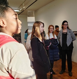 Students looking at something in a hallway.
