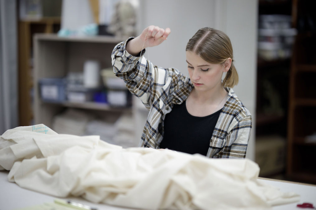 Student working with fabric for a theatre production