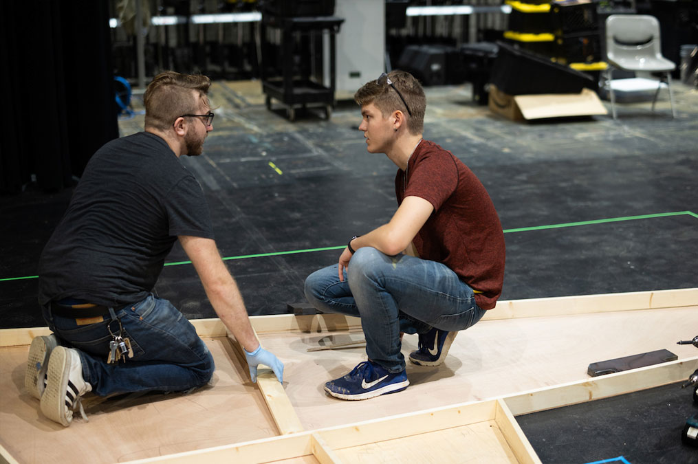 Students working together building the wooden backdrop