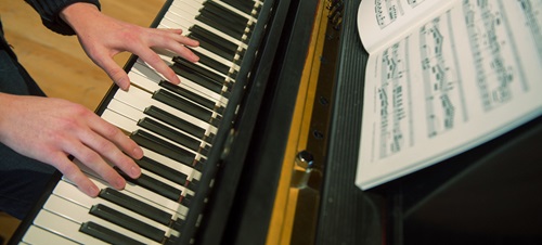 Hands playing a piano