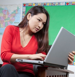 A student in classroom on her laptop.
