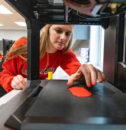 A student placing an item on a projector.