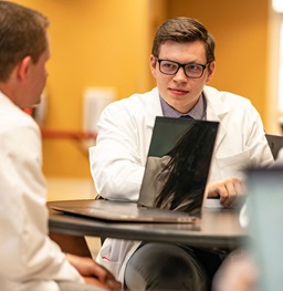 Two medical school students talk in a study lounge