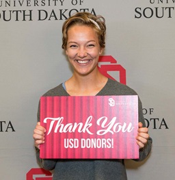 Female Student Holding Sign that Thanks USD Donors