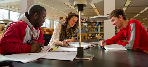 Three students doing homework in the ID weeks library.