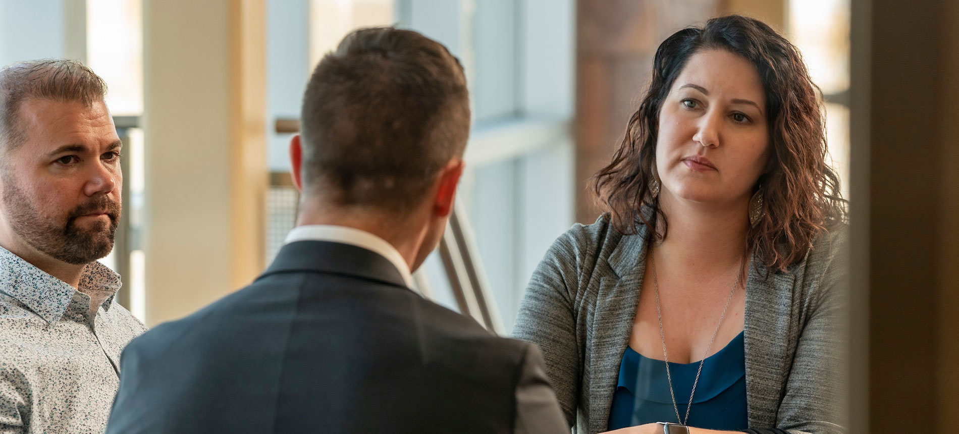 Three adults talking at a table