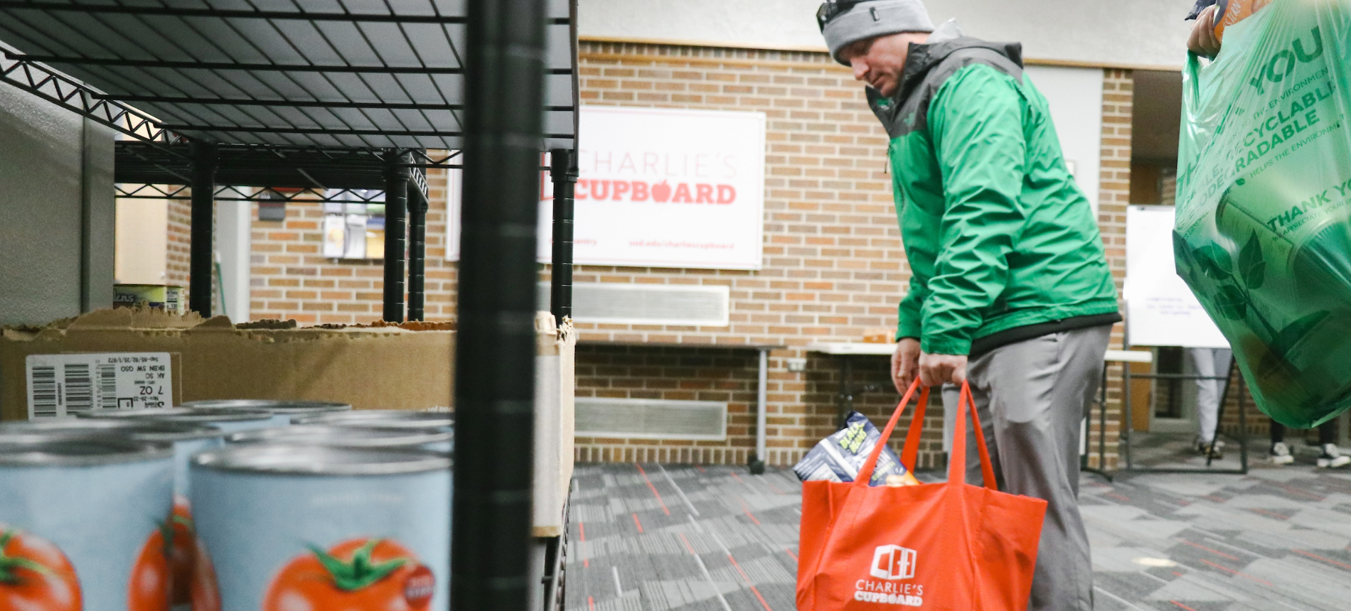 A student bringing food into Charlie's Cupboard food pantry.