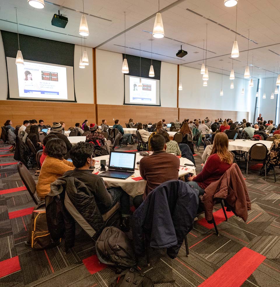 People sitting in a large room for a presentation