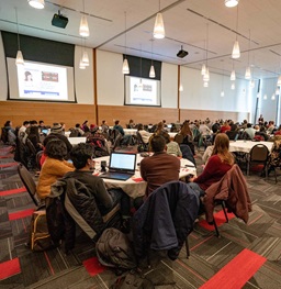People sitting in a large room for a presentation