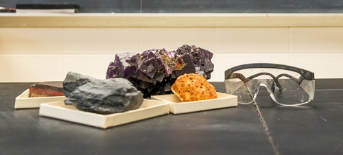 Rocks and crystals on a desk next to a pair of goggles