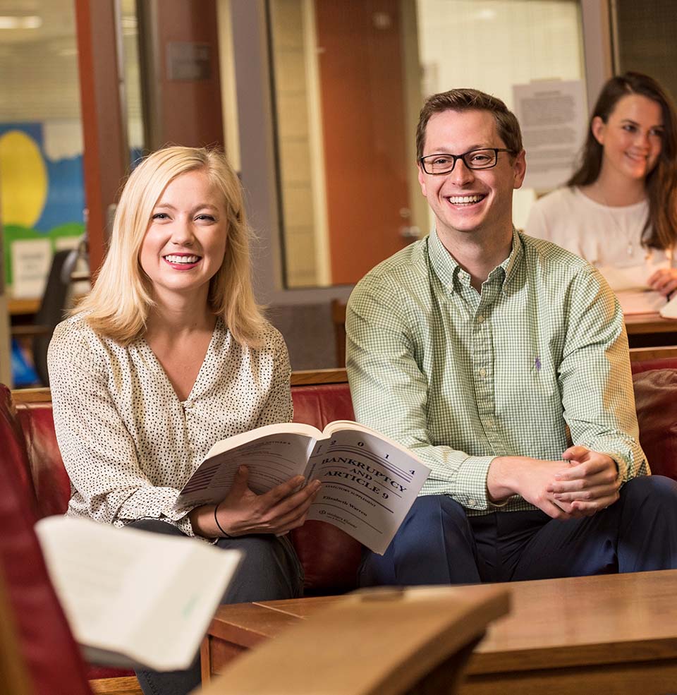 Students smiling while sitting.