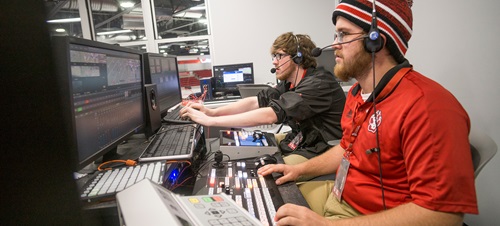 Male Students Working Control Board During Sporting Event