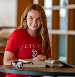 A student smiling doing homework.