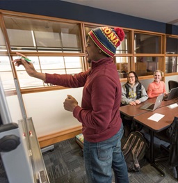 A student writing on a markerboard.