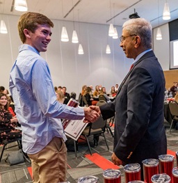 A Beacom student proudly shakes hands with the Dean of the Beacom school of Business