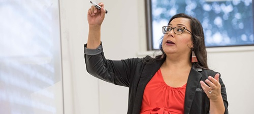 Professor Writing on a Whiteboard During a Lecture