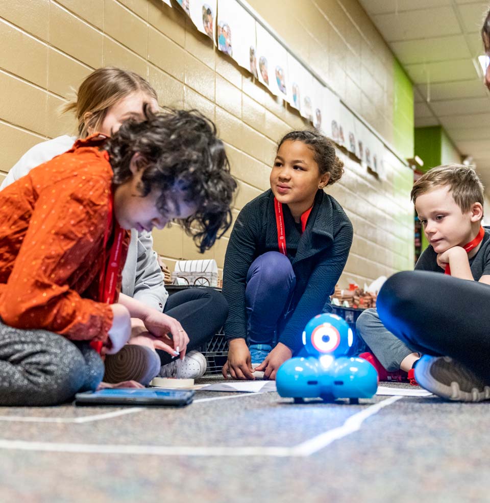 Elementary Students Using Tablet to Control Robot