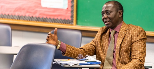 A man instructing from his desk.