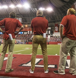 Football interns on the sideline at a game.