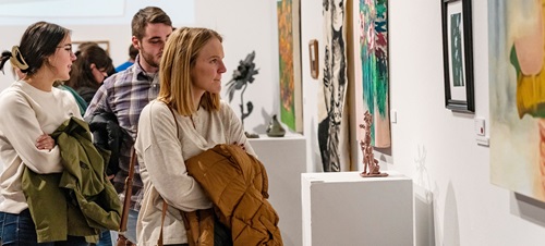 Current BFA students browse the gallery art at the annual Stilwell Show