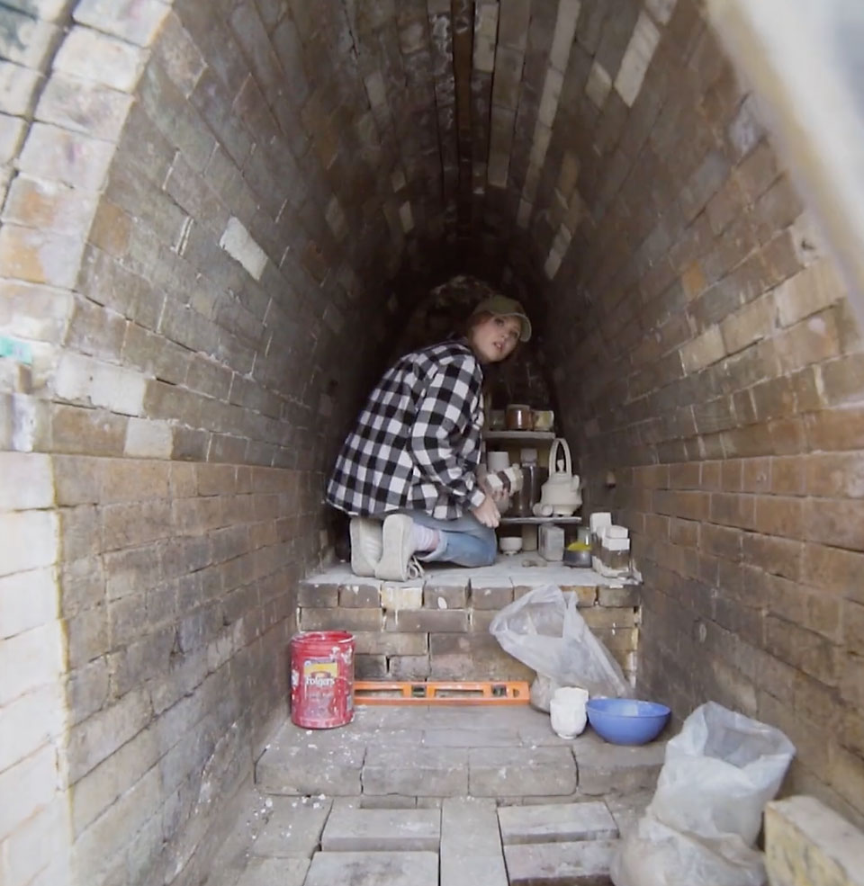 Student loads wood klin with projects 