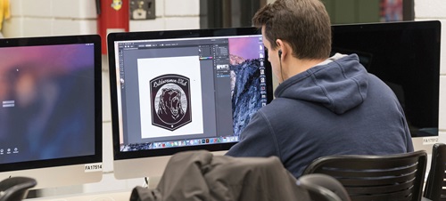 Graphic Design student works in the Mac lab on logo design