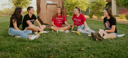 Students Sitting on the Campus Lawn Smiling