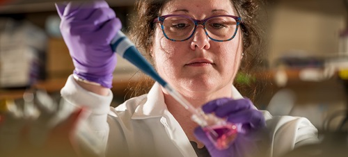 Photo of a researcher in a lab working with chemicals