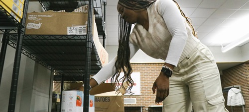 A student helping move food at Charlie's Cupboard food pantry on campus.