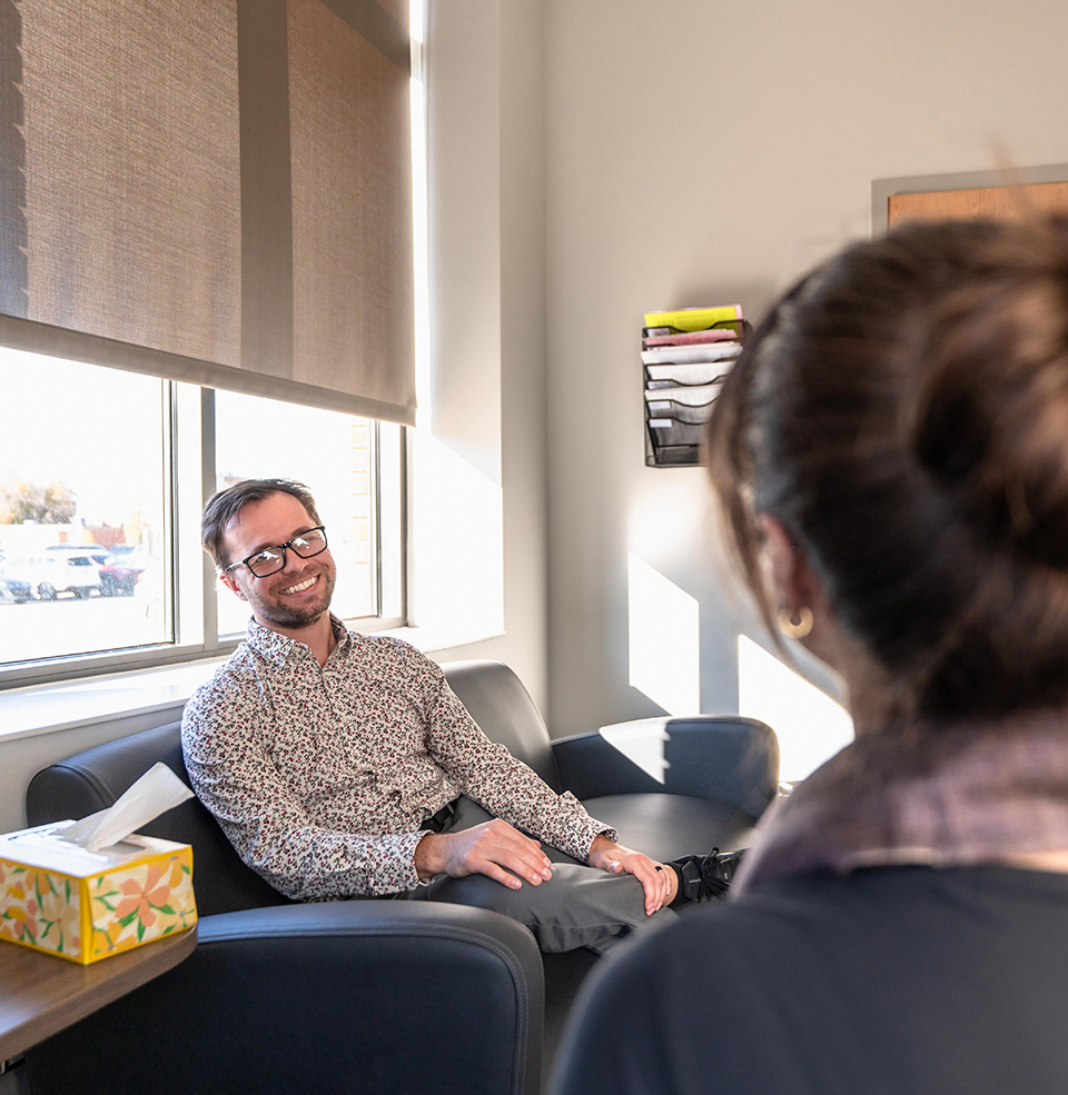 person on a couch talking to another person in an office setting