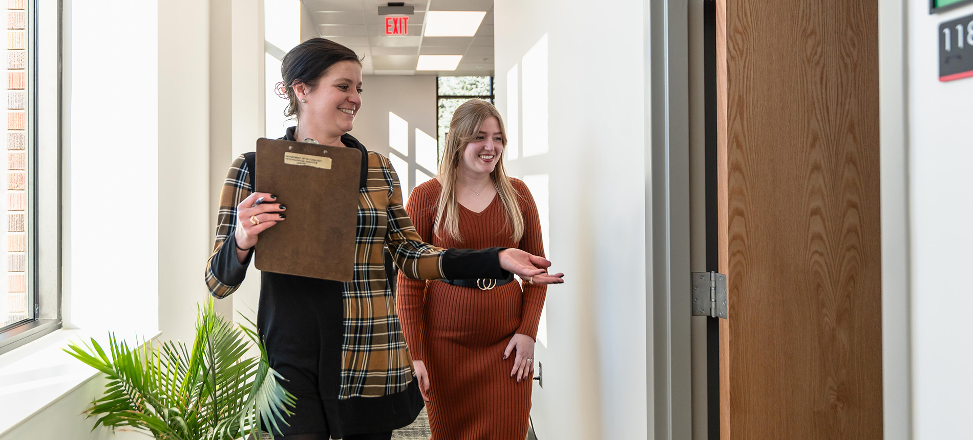 photo of two people walking down a hallway 