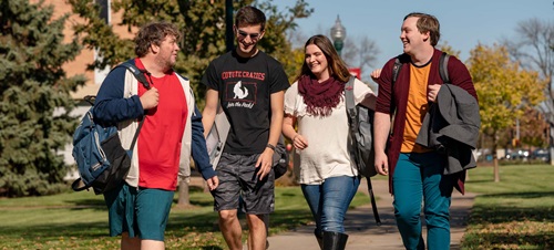 Four Students Walking Outside on Campus