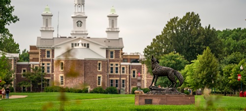 Main USD campus in the Summer, with Legacy statue and Old Main building present.