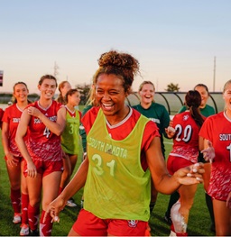 USD Women's soccer players celebrating post game and laughing.