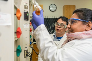 Two lab students doing biometric research in a lab on a cell model.
