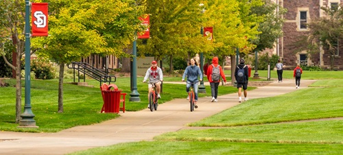 Students riding bikes and walking on campus