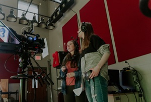 Two students operating a camera during the filming of a tv event in Al Neuharth for Media and Journalism.
