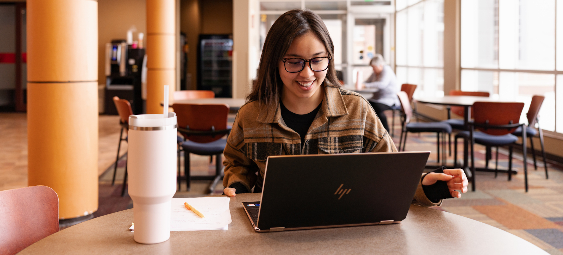 A sioux falls student smiling and typing on her keyboard.