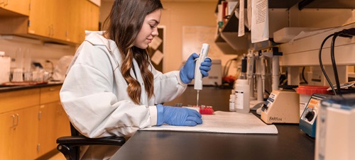 Female in White Lab Coat Working in a Research Lab