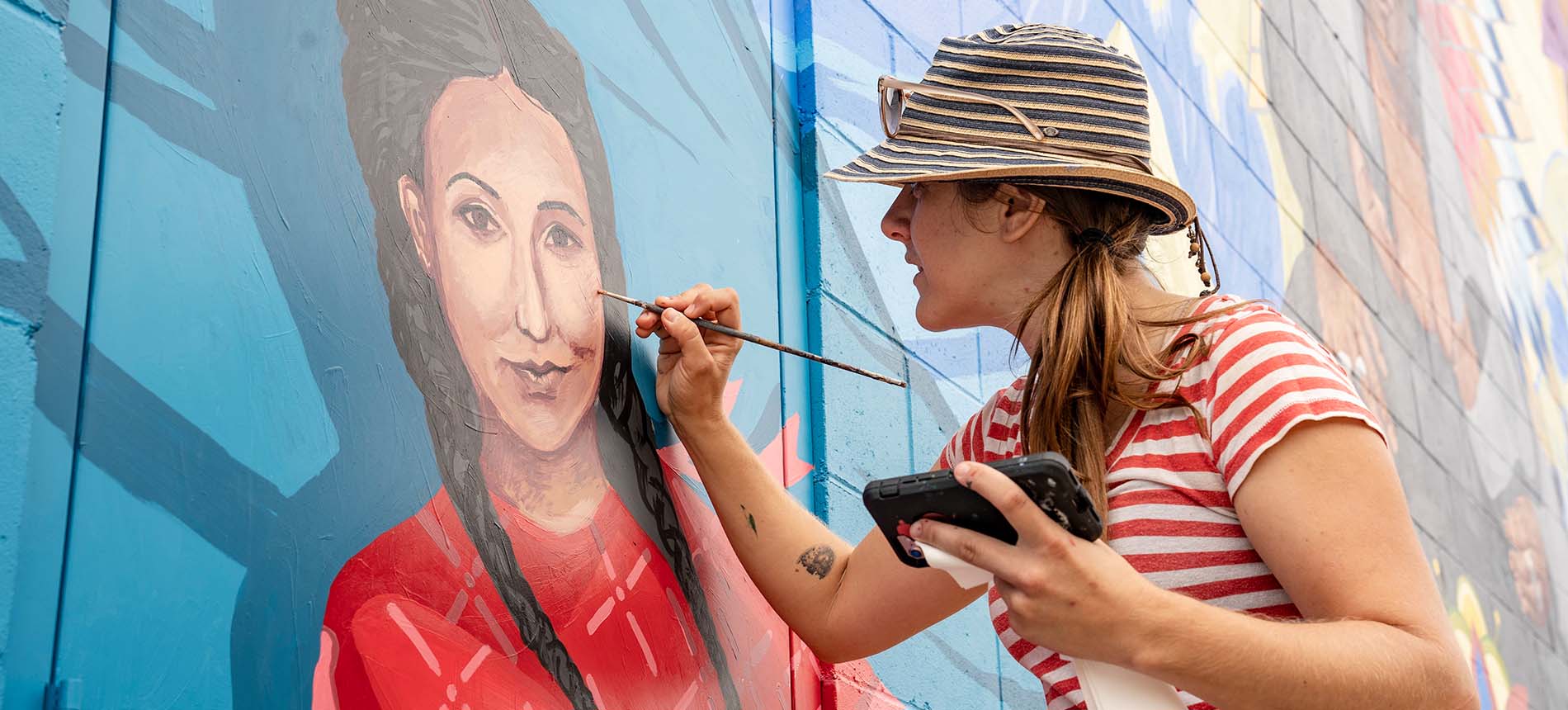  A student painting on the Vermillion mural.