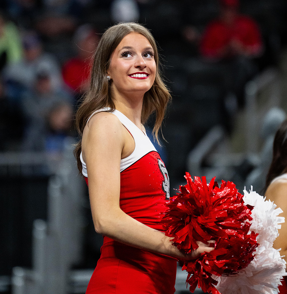 USD dance team member smiling on the sidelines at Summit League tournament