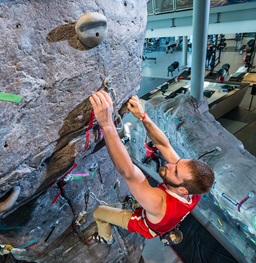 A man climbing the USD rock climbing wall.