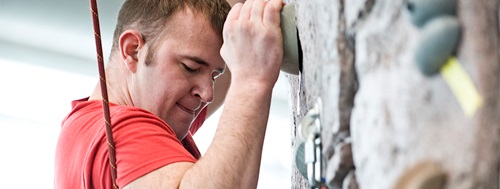 A student rock climbing in the Wellness Center.