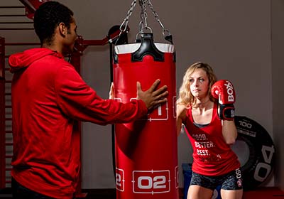 A USD student teaching another how to box a punching bag.