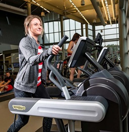 A USD student walking on an elliptical machine in the Wellness Center.