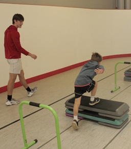 A personal trainer helping a child run.