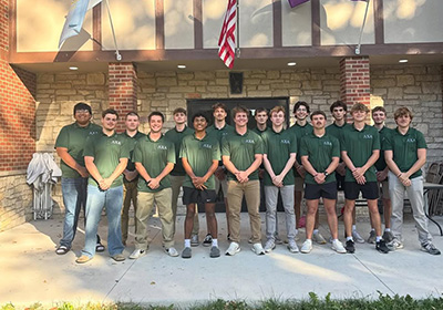 Lambda Chi Alpha group photo in front of fraternity house.