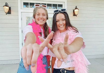 Sorority girls holding Yote hand symbols towards the camera.
