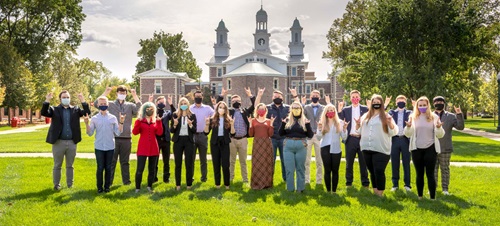 The Student Government Association posing in front of Old Main, holding up Yote hand signs.
